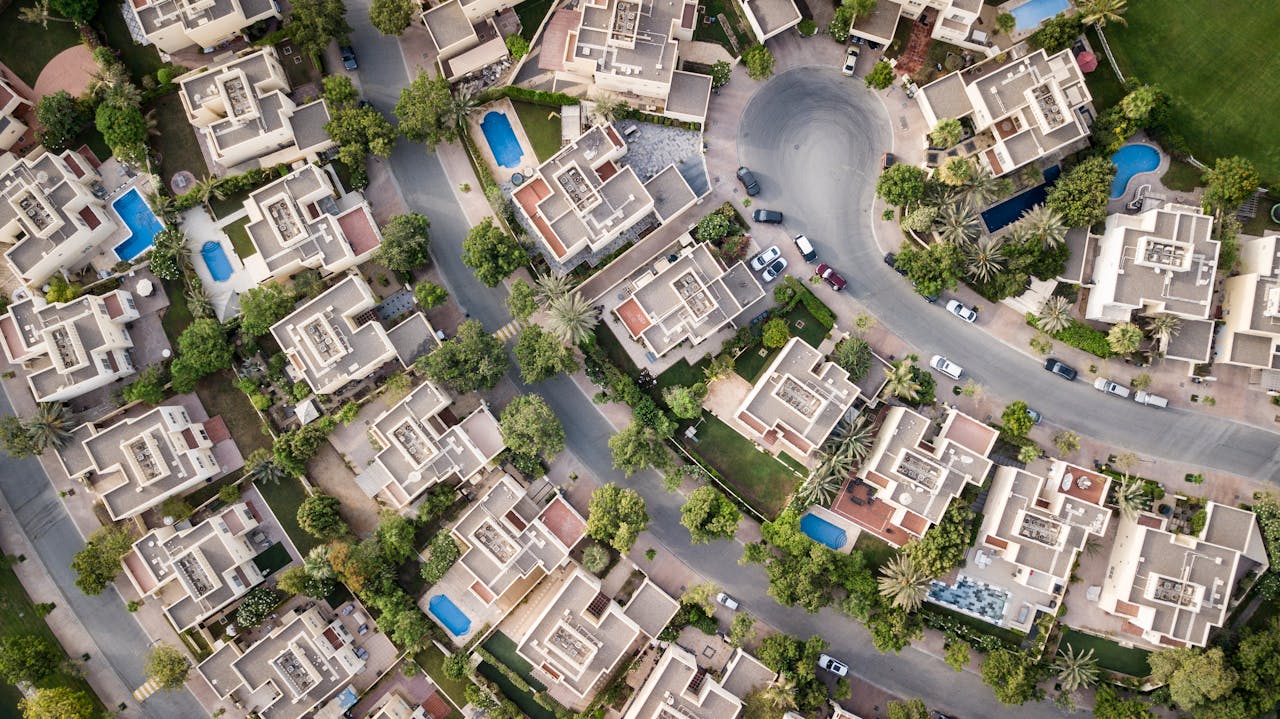 Mastering the First Impression: Your intriguing post title goes here Explore a stunning aerial view of a residential area in Dubai with lush greenery and swimming pools.